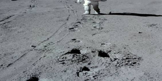 Een Apollo 15astronaut loopt naast de wielsporen van de maanwagen LRV1 Apollo 15 was de eerste Apollomissie waarbij een moon buggy werd meegenomen